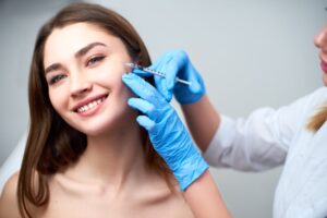 Young woman smiling while getting dermal fillers in Boca Raton, FL